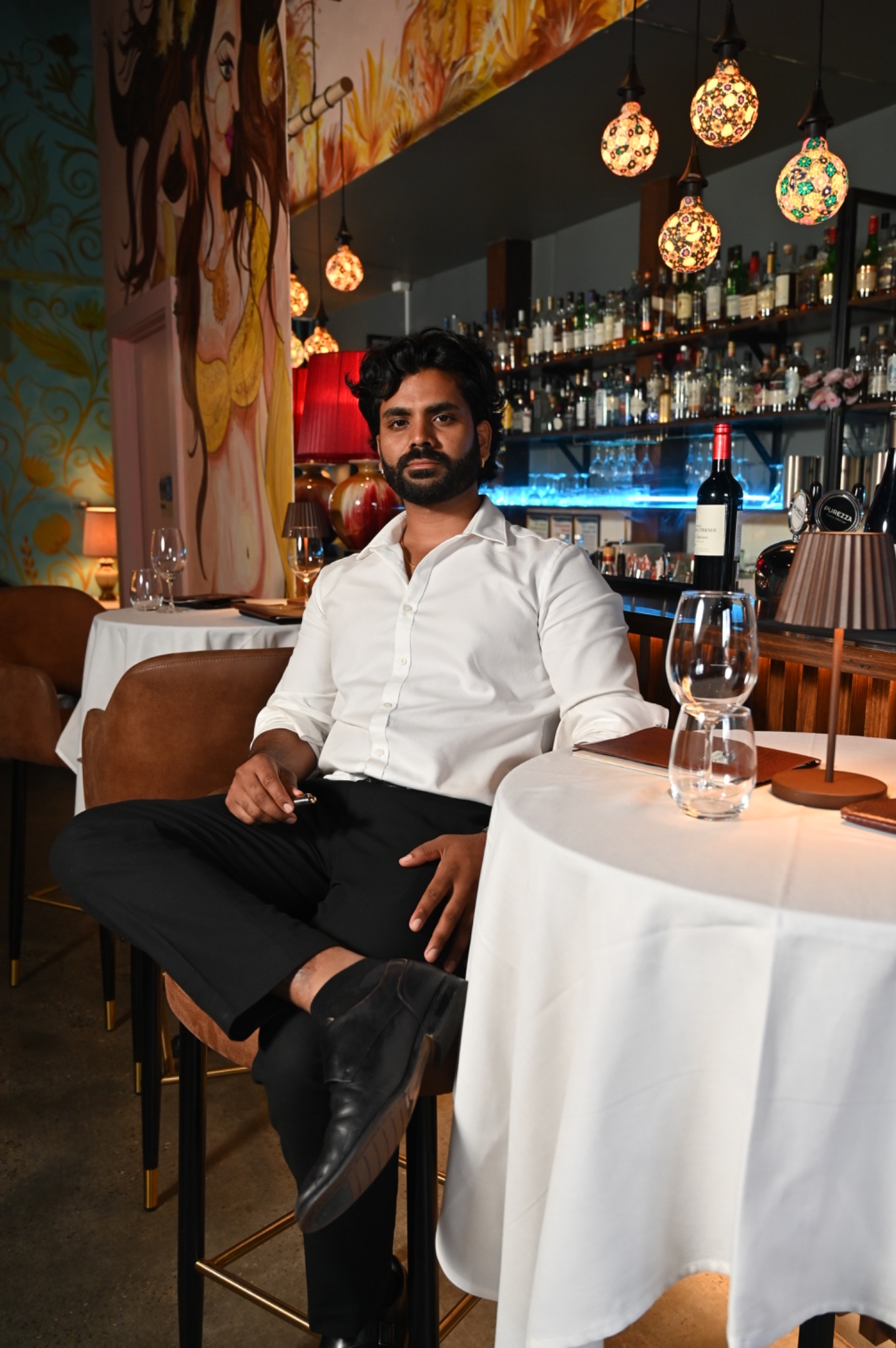 Ankit, founder of Bombay on Bay, seated beside the restaurant bar