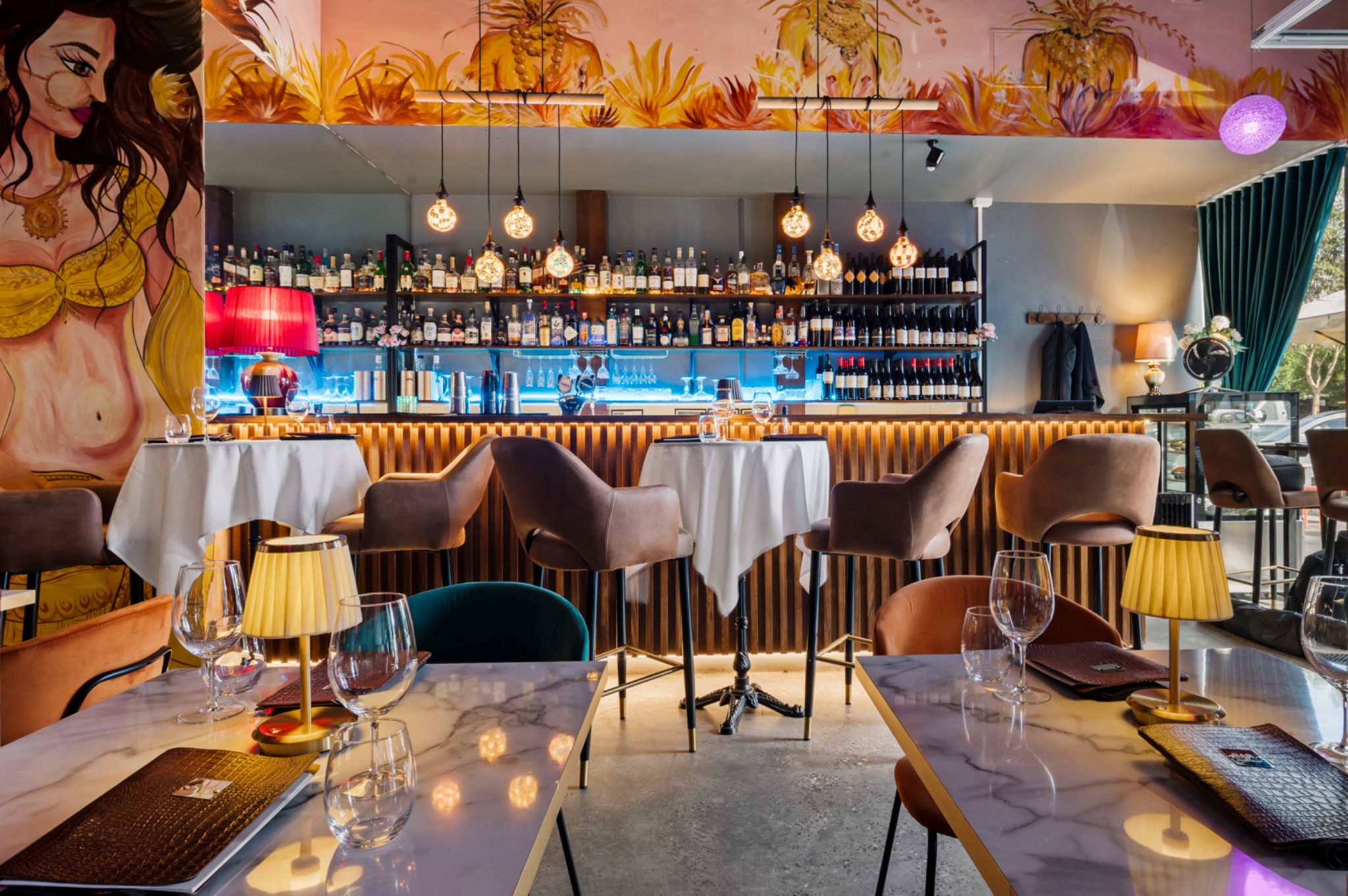 Marble tables, velvet chairs and colourful murals in Bombay on Bay's dining room