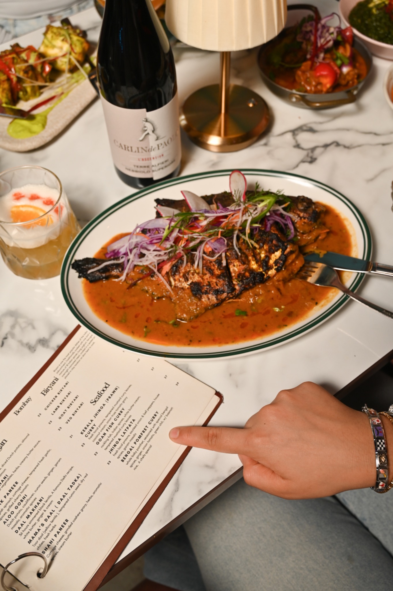 Whole tandoori fish with curry sauce, wine and the Bombay on Bay menu